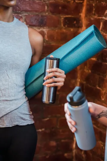 Woman with yoga mat — active and energized